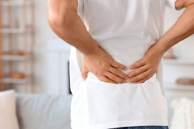 Genç adam sırt ağrısı evde, closeup acı