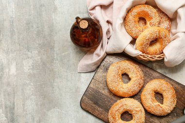 Tahta tahta ve gri arka planda susam tohumlu lezzetli simit kasesi.