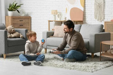 Babası ve küçük oğlu evde oyuncak arabalarla oynuyorlar. Babalar Günü.