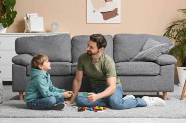 Baba ve küçük oğlu evde renkli bloklarla oynuyorlar. Babalar Günü.