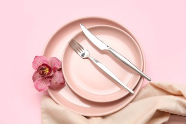 Pembe arka planda güzel orkide çiçekli şık masa ayarları