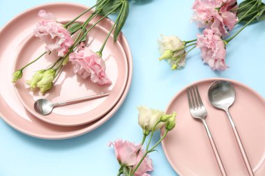 Mavi arka planda güzel östoma çiçekleri olan şık masa ayarları