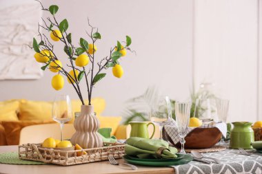 Taze narenciye ve güzel limon dallarıyla süslenmiş şık yeşil masa.