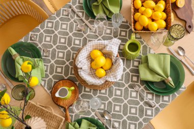 Bir sürü taze turtayla süslenmiş şık yeşil masa dekorasyonu ve yemek odasında güzel limon ağacı dalları.