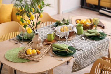 Taze narenciye ve güzel limon dallarıyla süslenmiş şık yeşil masa.