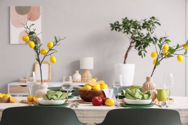 Yemek odasında bir sürü taze turta ve limon ağacı dallarıyla süslenmiş şık bir masa.