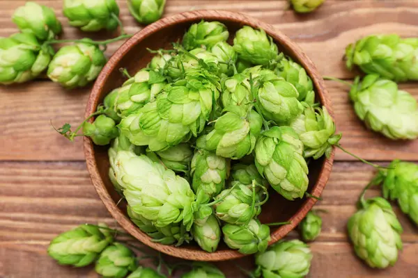 Kahverengi ahşap arka planda yeşil kozalaklar