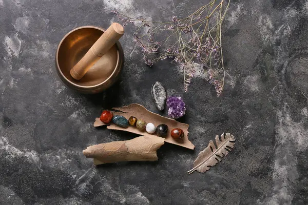 Arka planda çakra taşları, çiçekler ve Tibet şarkı kasesi seti