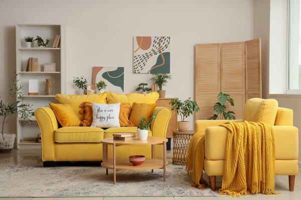 Желтый диван, кресло и журнальный столик в интерьере гостиной