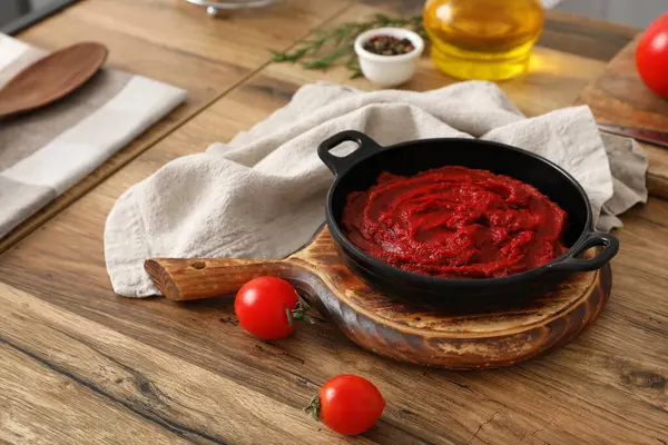 Lezzetli domates ezmeli tava ve ahşap masada malzemeler.