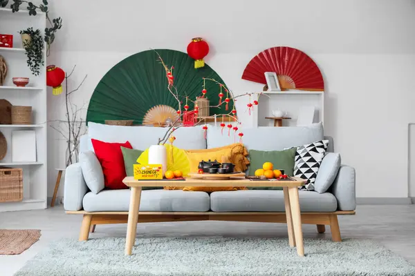 Çin Yeni Yıl kutlamaları için kanepe, masa ve dekorla aydınlık oturma odasının içinde.