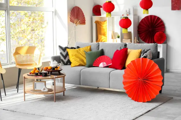 Çin Yeni Yıl kutlamaları için gri kanepe, masa ve dekorla aydınlık oturma odasının içinde.