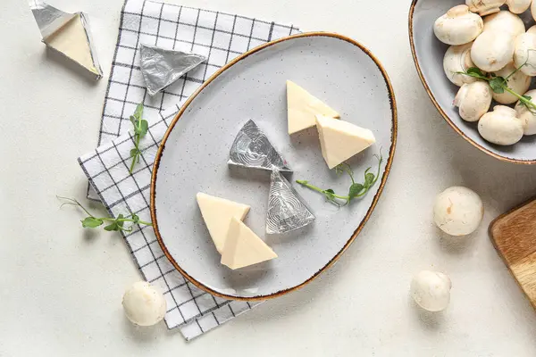 Lezzetli işlenmiş peynir, mantar ve peçeteyle dolu bir tabak.