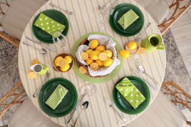 Yemek odasında bir sürü taze limonla dekore edilmiş şık masa seti.