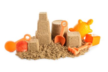 Beyaz arka planda kumdan ve plaj oyuncaklarından yapılmış bir kale.