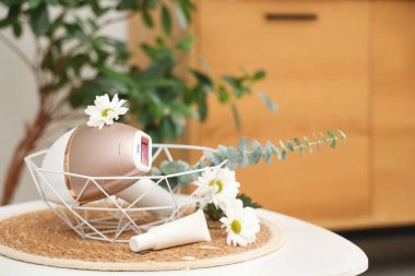 Modern fotokopi makinesi ve banyo masasındaki çiçeklerle dekoratif kase.