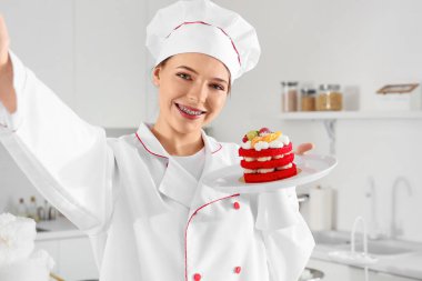 Lezzetli pastalı kadın pastacı mutfakta selfie çekiyor, yakın plan.