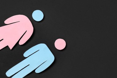 Siyah arka planda erkek ve kadın kağıt figürler. Transseksüel kavramı