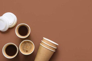 Kahverengi arka planda tek kullanımlık kahve fincanları