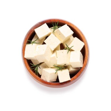 Beyaz arka planda izole edilmiş lezzetli tofu peyniri parçalarıyla dolu bir kase.