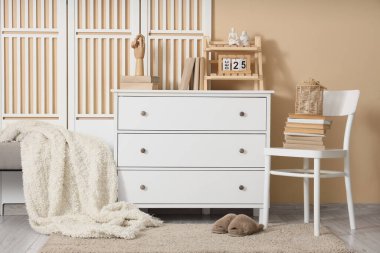 Klozet, sandalye ve kitaplarla dolu bir oturma odası.