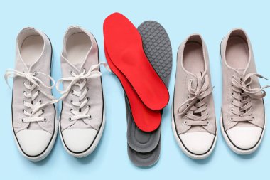 Açık mavi zemin üzerinde ortopedik tabanlı ayakkabılar