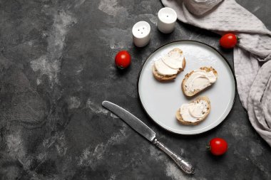 İşlenmiş peynirli lezzetli bruschetta tabağı ve siyah arka planda taze domates.