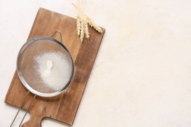 Un, ahşap tahta ve arka planda çivili metal elek.