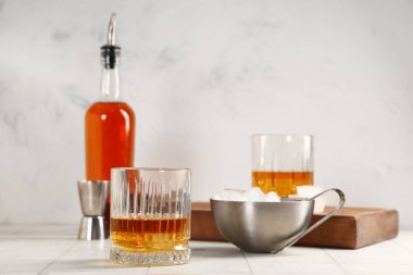 Arka planda bulanık duran bir bardak rom ve bir kase buz. Yakın çekim.