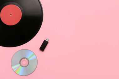 Pembe arka planda küçük diskler ve USB flaş bellek. Evrim kavramı