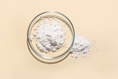 Sarı arka planda toz örneği olan petri kabı