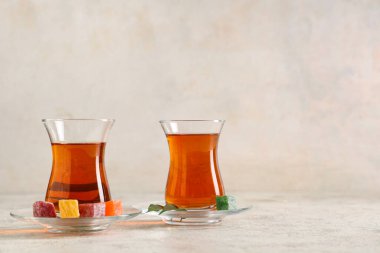 Hafif arkaplanlı ve yapraklı bir bardak Türk çayı.