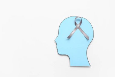 Beyaz arka planda gri farkındalık kurdelesi olan kağıt insan kafası. Beyin kanseri kavramı