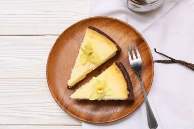 Beyaz ahşap arka planda tatlı vanilyalı cheesecake tabağı