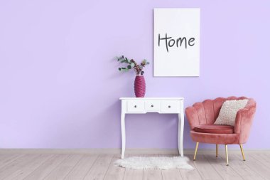 Odada mor duvarın yanındaki klozette çiçek vazosu olan koltuklar.