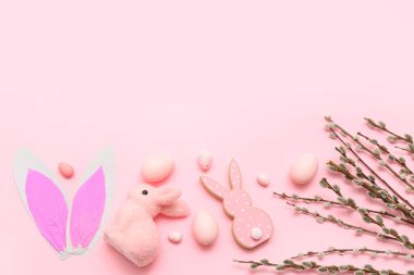 Pussy willow branches with Easter eggs and bunnies on pink background
