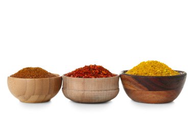 Beyaz arka planda farklı baharatlı ahşap kaseler.