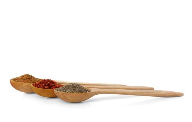 Beyaz arka plan üzerinde izole farklı baharatlar ile tahta kaşıklar