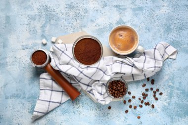 Portafilterli bir fincan kahve, mavi grunge arka planda bir kase toz ve fasulye.