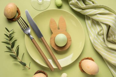 Yeşil arka planda Paskalya yumurtaları ve okaliptüs dallarıyla güzel bir masa.