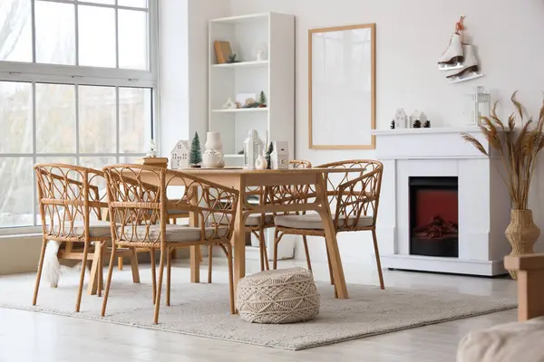 Odanın içinde yemek masası, şömine ve kış dekoru var.