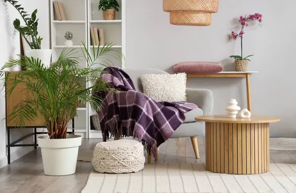 Modern oturma odasının içinde raf üniteleri, sehpa ve koltukta mor ekose.