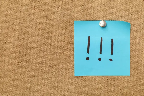 Üzerinde ünlem işaretleri olan yapışkan bir not.