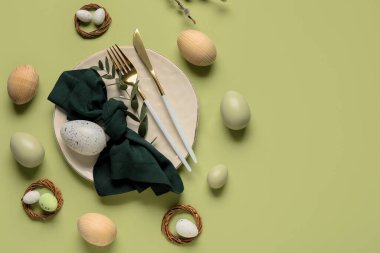 Yeşil arka planda Paskalya yumurtaları ve okaliptüs dallarıyla güzel bir masa.