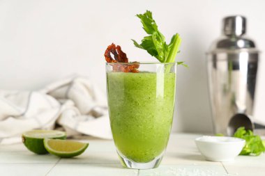 Beyaz fayanslı pastırma ve kerevizle süslenmiş bir bardak Bloody Mary kokteyli.