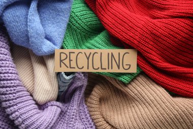 Farklı kıyafetlerdeki RECYCLING tabelasının yakın görünümü