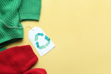 Sarı arkaplanda geri dönüşüm etiketi olan kıyafetler
