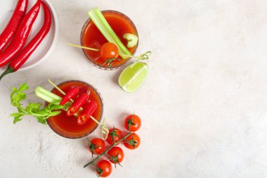 Beyaz arka planda kırmızı biber, kereviz ve limonlu Bloody Mary kokteyli.