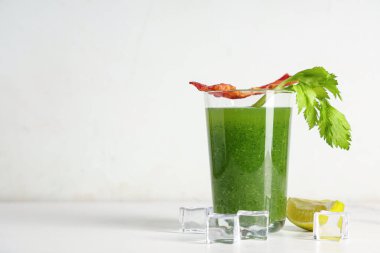 Beyaz arka planda domuz pastırması, kereviz ve limonlu yeşil Bloody Mary kokteyli.