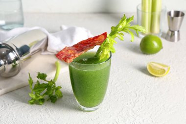 Beyaz arka planda pastırmalı, kerevizli ve limonlu yeşil Bloody Mary kokteyli.